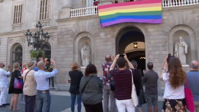 La bandera LGTBI ondea a modo de pancarta en la fachada del Ayuntamiento de Barcelona
