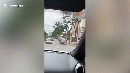 Motorcycle rider carries huge pile of trash in Vietnam