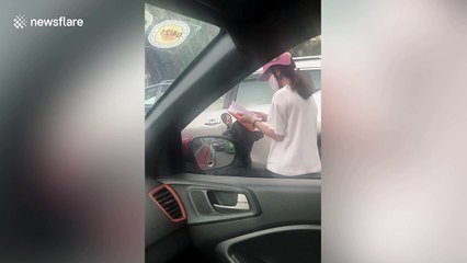 Student stuck in traffic jam on scooter does some last-minute revision