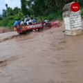 Watch: Tractor with a dozen people onboard overturns in flooded stream in Andhra