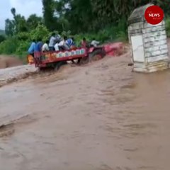 Watch: Tractor with a dozen people onboard overturns in flooded stream in Andhra