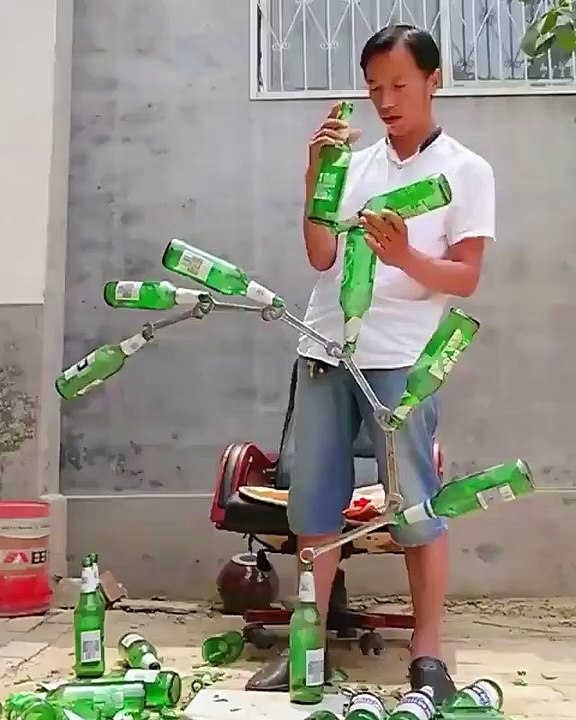 Il réussit à dresser une tour  fait de bouteilles et de clés, et à le maintenir en parfait équilibre