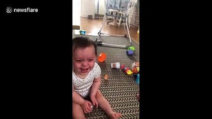Adorable baby cannot stop laughing at his mum while she juggles