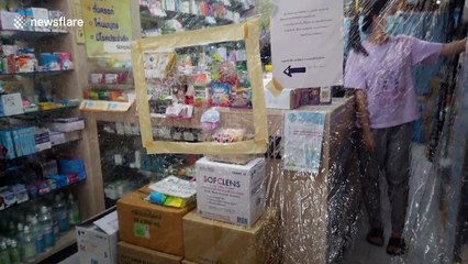 Pharmacy uses large plastic sheet covering counter to protect against Covid-19