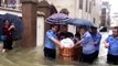 Chinese police officers transport students in water bucket through deep floodwater to exam centres