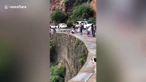 Man dangerously hangs child off cliff to take photos in north China