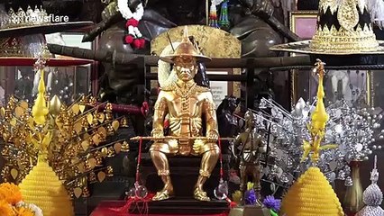 Buddhist followers crawl under ancient wooden bed for good luck in Thailand