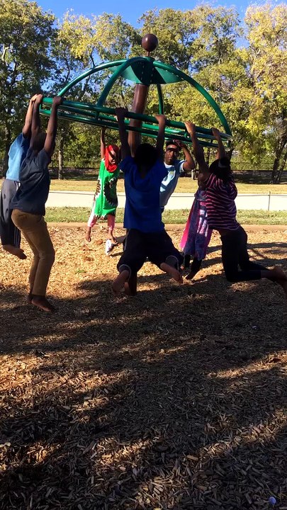 Large Group of Kids Spinning around on Playground Equipment