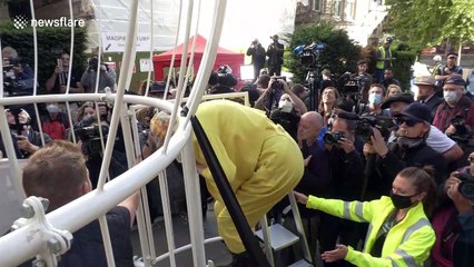 Bizarre! Dame Vivienne Westwood suspended 10 ft in the air inside giant bird cage in London