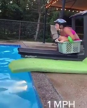 Elle s’amuse avec le panier à linge pour plonger dans la piscine, et cela semble amusant