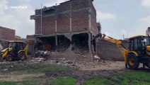 JCB driver has close shave when building collapses around his vehicle during demolition in India