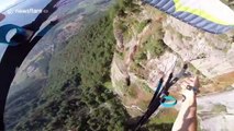 Speed flyer glides over stunning waterfall scene on French mountain