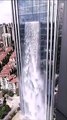 Une cascade de 100 mètres de haut se déverse sur le flanc d'un gratte-ciel en chine