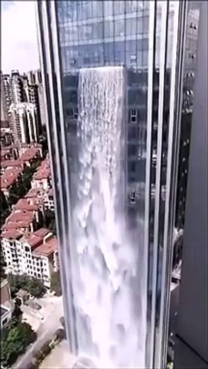 Une cascade de 100 mètres de haut se déverse sur le flanc d'un gratte-ciel en chine