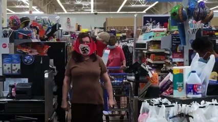 Una pareja compra en un supermercado con sus mascarillas decoradas con la esvástica nazi
