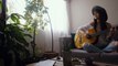 woman-playing-an-acoustic-guitar in her living room