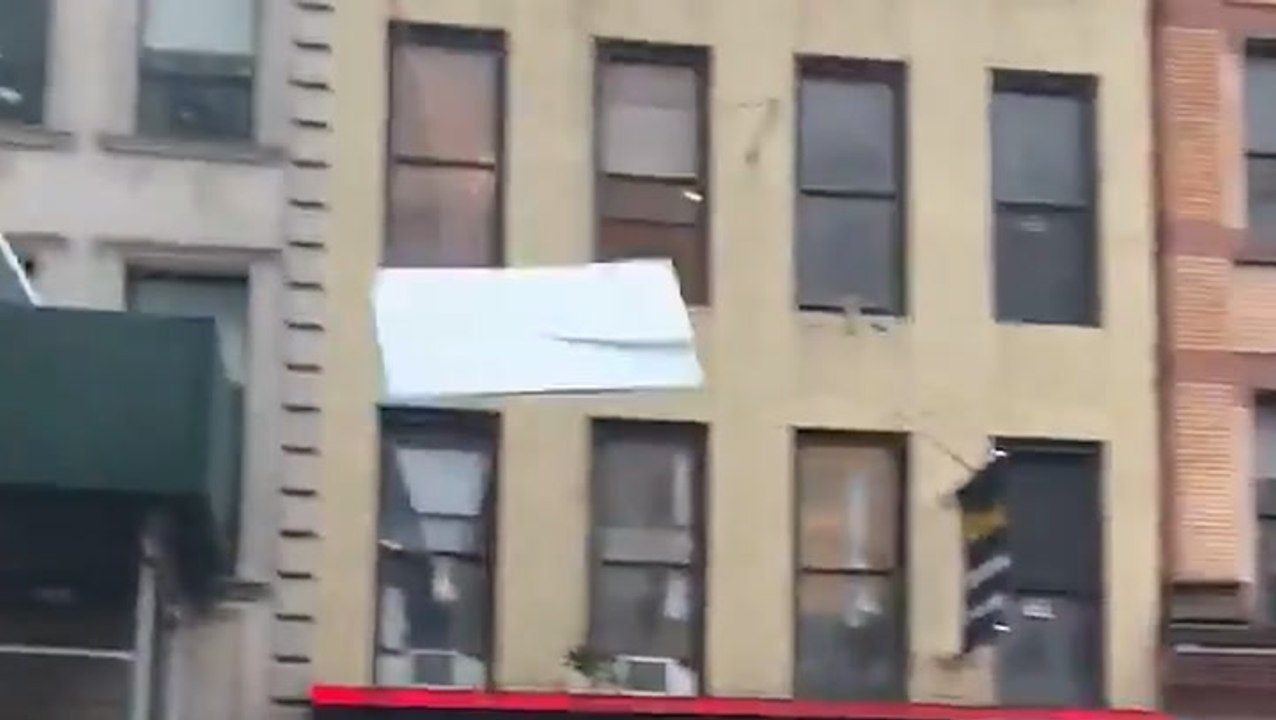 Flying debris narrowly misses moving car in New...