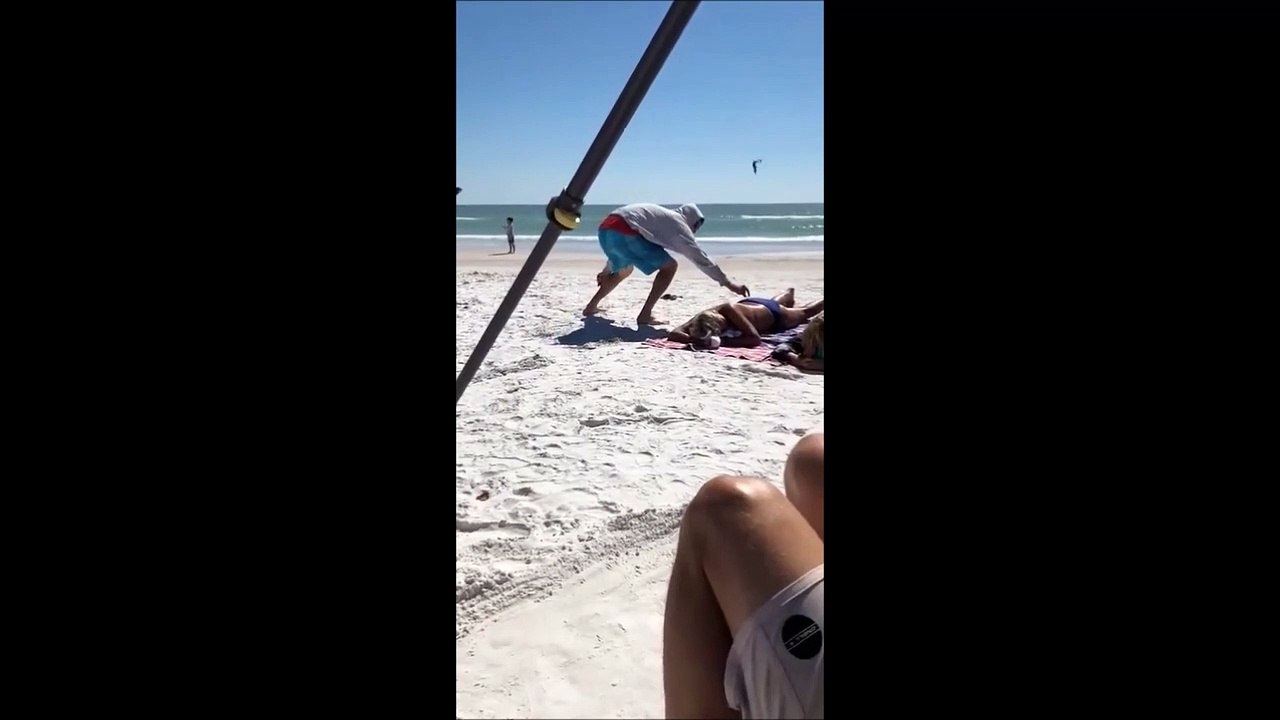 Il s’amuse à attirer des mouettes  sur une femme qui bronze