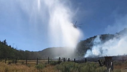 Helicopter dumps water to slow Pine Gulch Fire