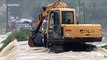 Firefighters use excavator to rescue three-wheeler driver trapped on flooded bridge