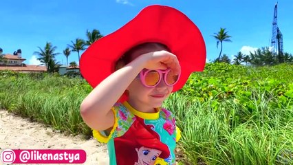 Nastya and dad play on the beach with toys
