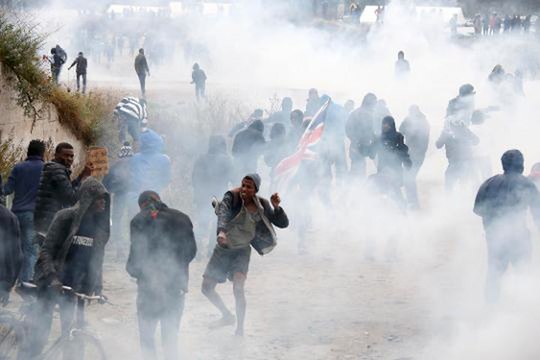 Police clash with migrants and protesters outside France's Calais migrant camp