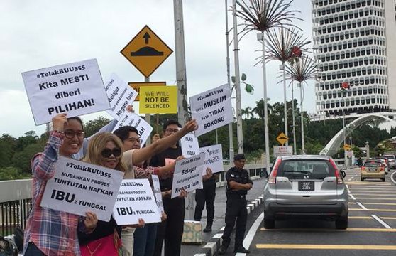 Activist Siti Kasim protests hudud bill outside Parliament