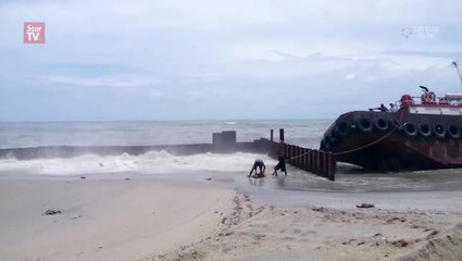 Stormy waves force tugboat to run aground