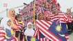 Tailor busy sewing outfits made from Jalur Gemilang