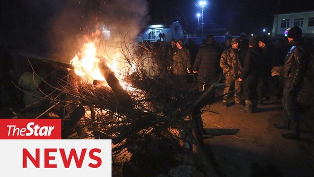 Fearing infection, residents protest coronavirus evacuees landing in Ukraine