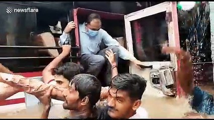 Terrifying moment Indian commuters forced to swim from bus submerged in floodwaters