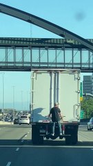 Man Hangs Onto Truck Traveling Along Highway