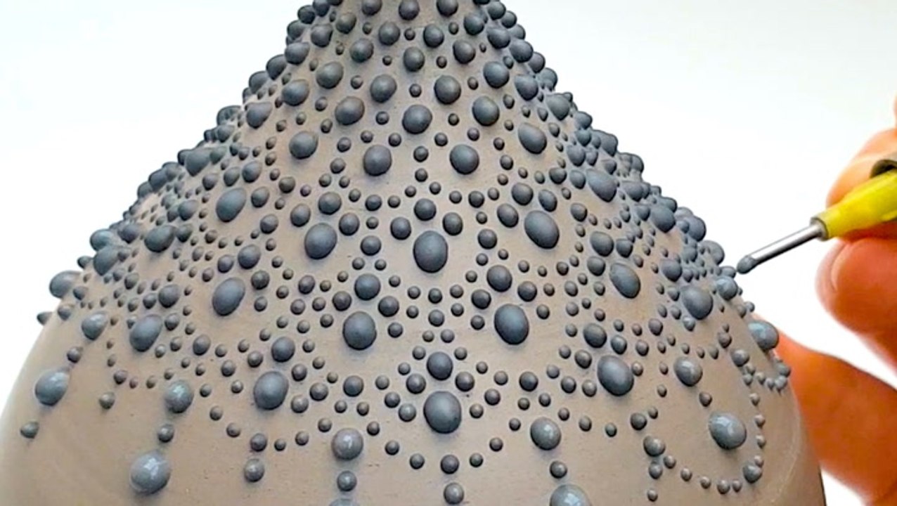 Artist creates dotted pottery designs
