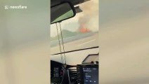 Motorists drive alongside flames from fires in Napa County, California