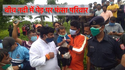 बीच नदी में पेड़ पर फंसा परिवार