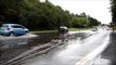 Motorists drive through flood water on Scot Lane, Wigan