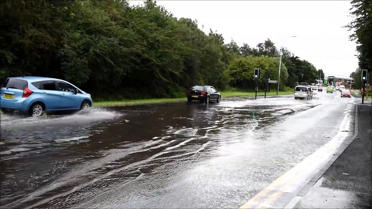 Motorists drive through flood water on Scot Lan...
