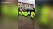 Chinese firefighters stand in deep floodwater to evacuate children from submerged kindergarten