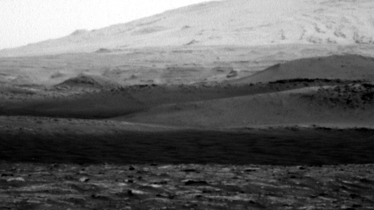 Un diablo de polvo pasa frente al rover Curiosity en Marte