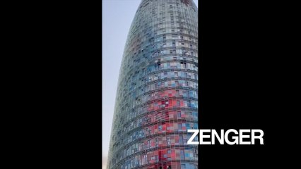 Barefoot man climbs tower in Barcelona