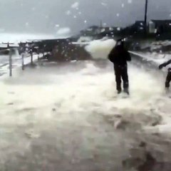 Faire des boules de neige en plein été en bord de mer... avec l'écume en pleine tempête