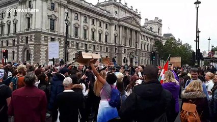 Anti-lockdown protesters try to remove police officer's mask