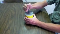 Il vous montre comment ouvrir une boite de conserve avec une cuillère