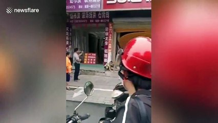 Car smashes through shop's shutter in southern China