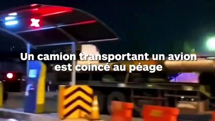 Un camion transportant un avion reste coincé à un péage