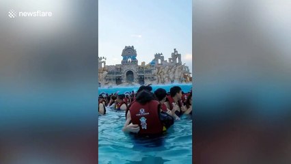 Chinese man on inflatable dolphin flies over crowds at water park's wave machine