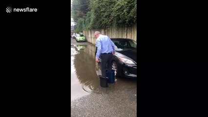 Man gets savvy and uses buckets to wade through floodwater to rescue car