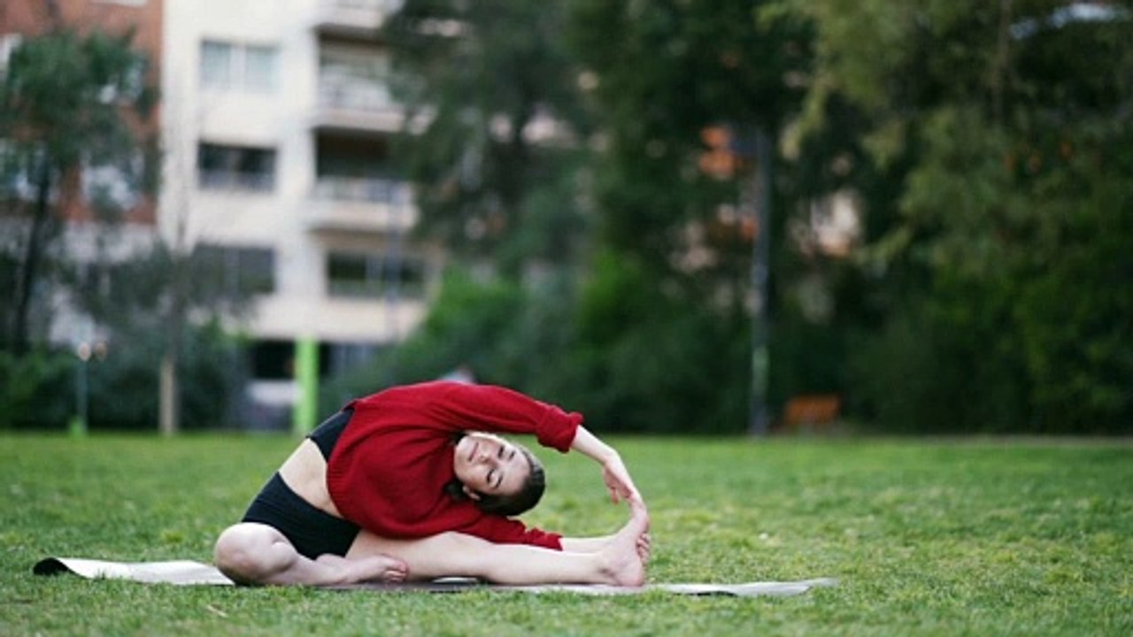 Pretty girl doing yoga in the park.