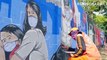 Petugas PPSU Bukit Duri menyelesaikan pembuatan mural yang berisi pesan waspada penyebaran virus Corona di Bukit Duri, Jakarta.