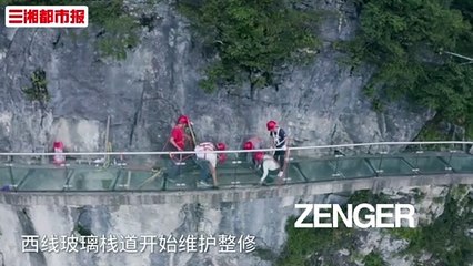 Workers replace glass panels on scenic mountain path